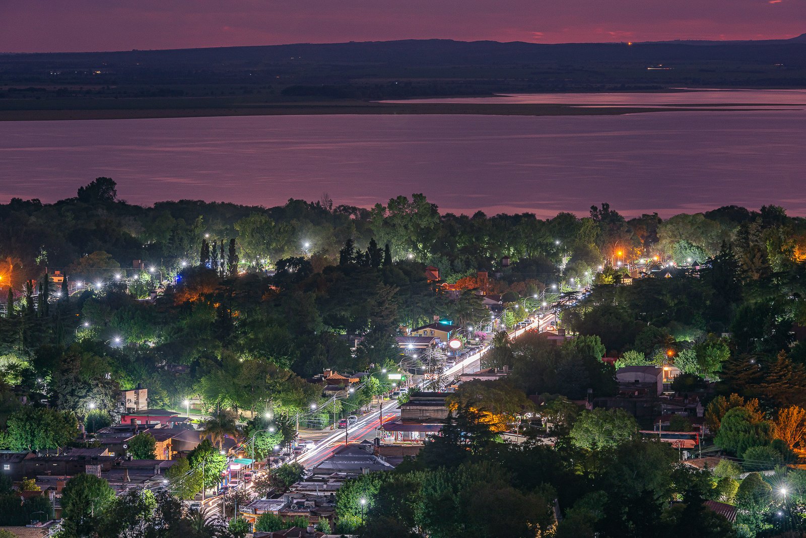 Villa Rumipal iluminada junto al lago al caer la noche
