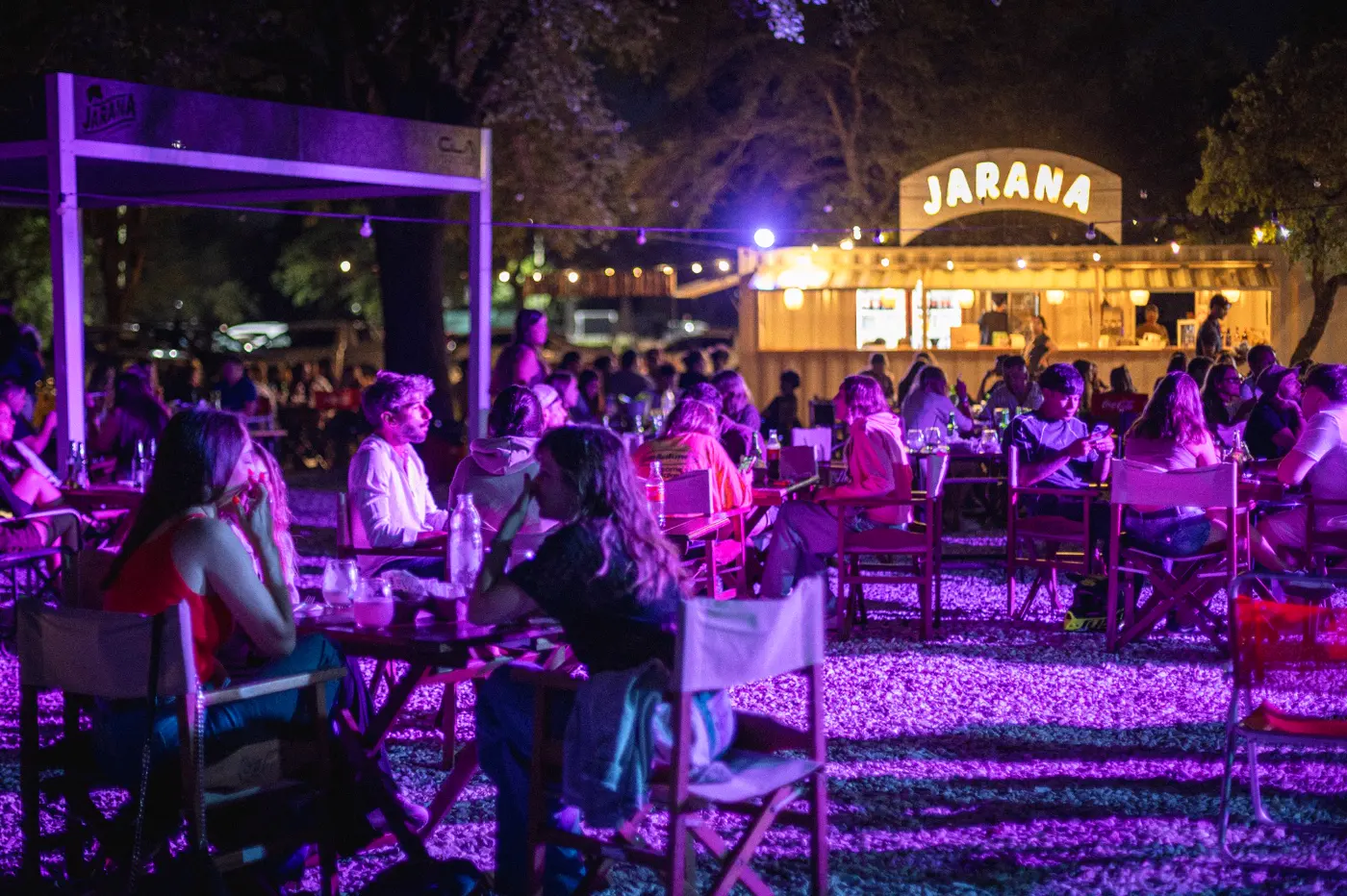 Jarana de noche, con mesas iluminadas y la barra al fondo